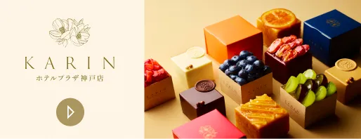 KARIN ホテルプラザ神戸店のサイトへ(新しいウィンドウで開きます)。花のロゴとともに、オレンジやブルーベリー、キウイなどの果物をのせた色とりどりの箱入り焼き菓子が並ぶバナー。