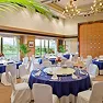 丸テーブルと青いクロス、椅子がセッティングされた華やかな宴会場