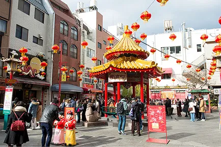 赤い提灯が連なる南京町の広場。中華風のあずまやの周りに多くの観光客が集まっている。