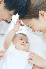 赤ちゃんの頭をなでる両親の手元を写したクローズアップ。