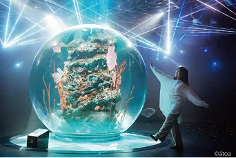巨大な球体水槽が幻想的に光り輝く水族館の内部