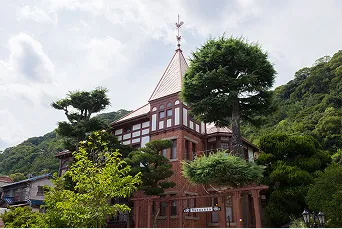 緑の木々に囲まれたクラシカルな洋風建築「風見鶏の館」