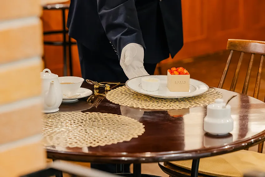 スタッフがテーブルにデザートを提供する様子