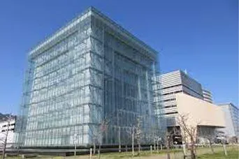 青空の下に建つ、ガラス張りの立方体の建物が特徴的な人と防災未来センターの外観
